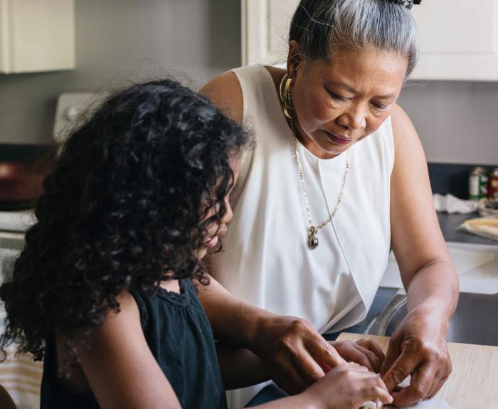 Grandmother teaching her child how to cook 